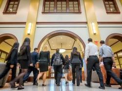 Students walking in school of business entryway